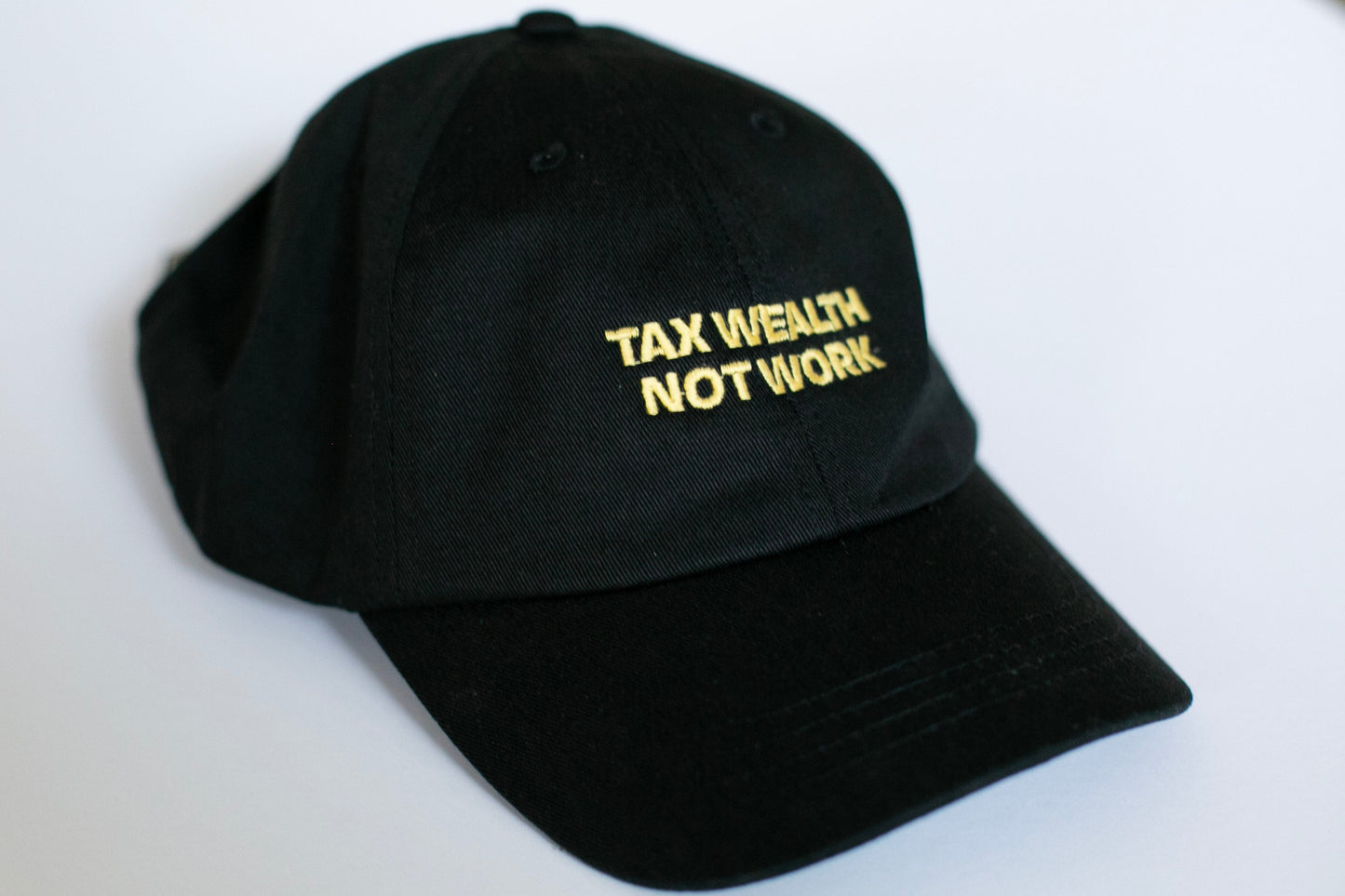 Black cap with 'TAX WEALTH NOT WORK' text in gold on a white background