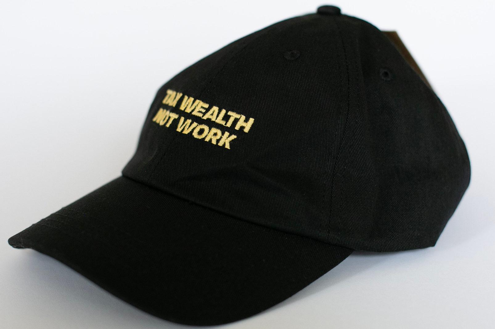 Black cap with 'The Wealth Not Work' text on a white background